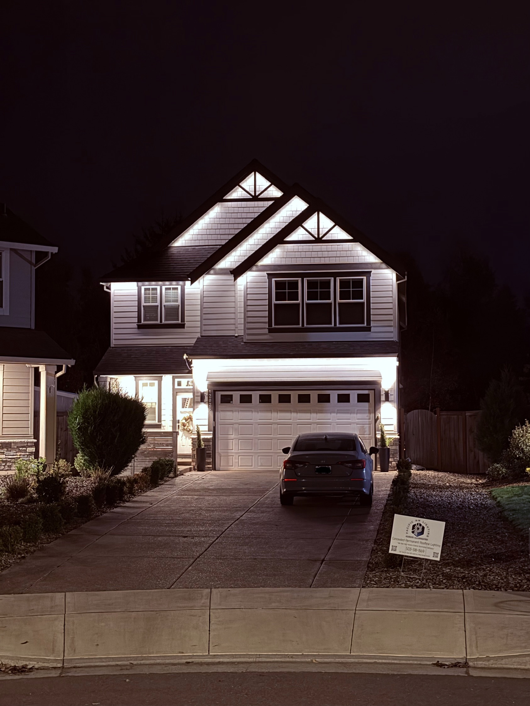 Home with colorful year-round permanent LED roofline lighting